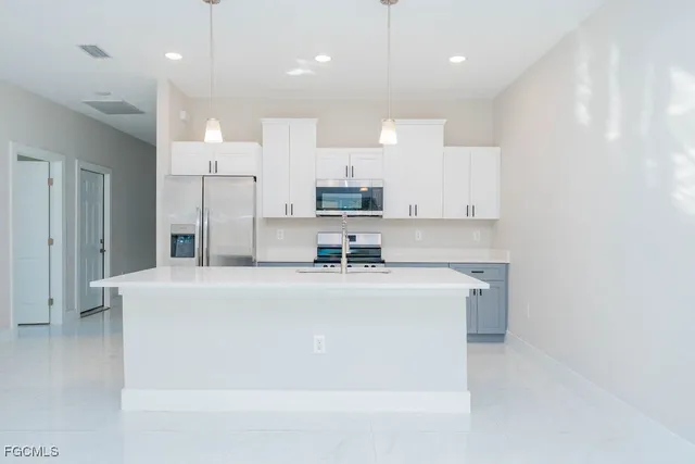 a kitchen with stainless steel appliances a refrigerator sink and stove