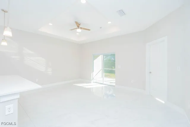 an empty room with windows and a ceiling fan