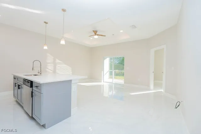 a view of a kitchen with a sink and dishwasher with wooden floor
