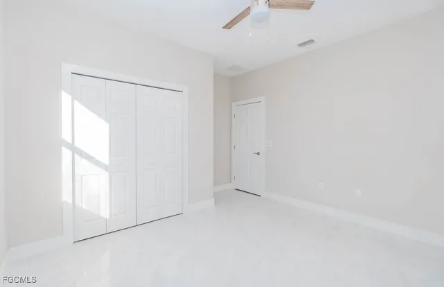an empty room with windows and closet