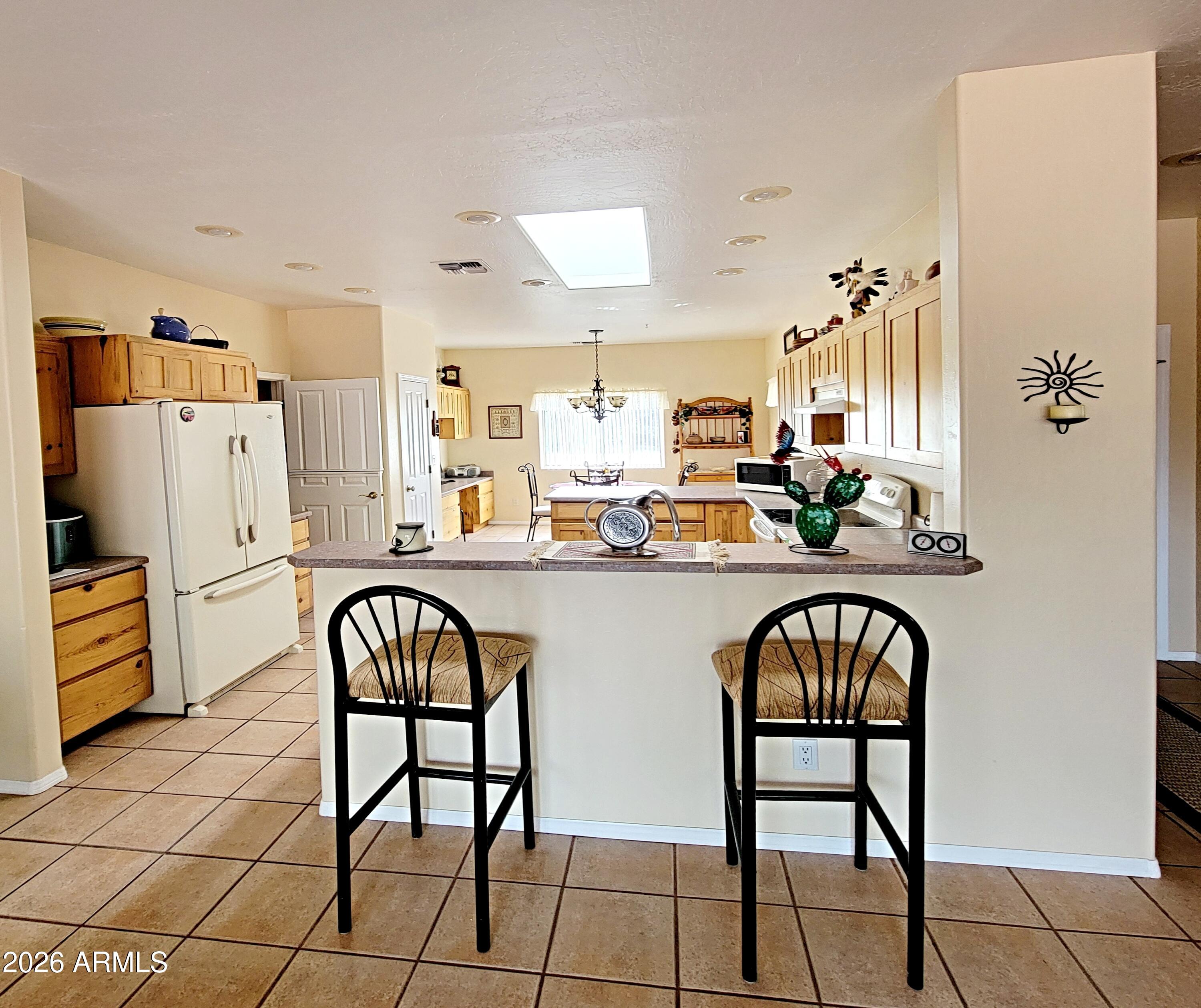 5665 North Vicki Lane Rimrock, AZ 86335 - Photo 7 of 27 a kitchen with stainless steel appliances a white table chairs and a refrigerator