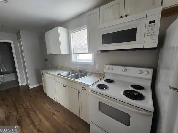 a kitchen with a stove microwave and sink