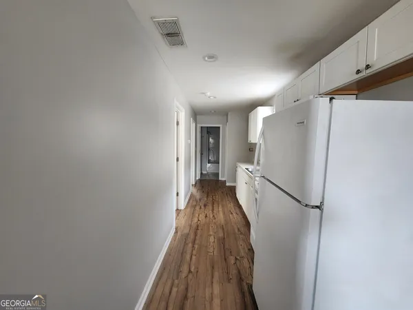 a view of a hallway with wooden floor