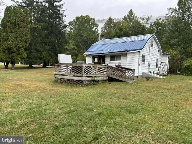 a view of a house with a yard and deck