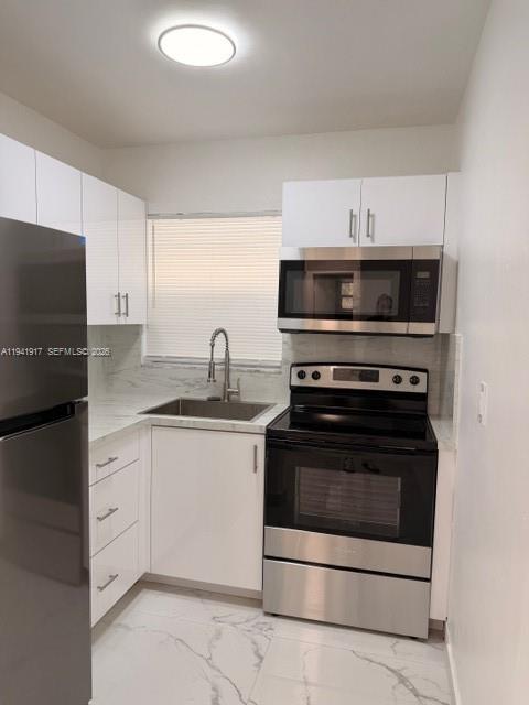 2332 Fillmore Street, Unit 612 Hollywood, FL 33020 - Photo 2 of 8 a kitchen with granite countertop white cabinets and stainless steel appliances