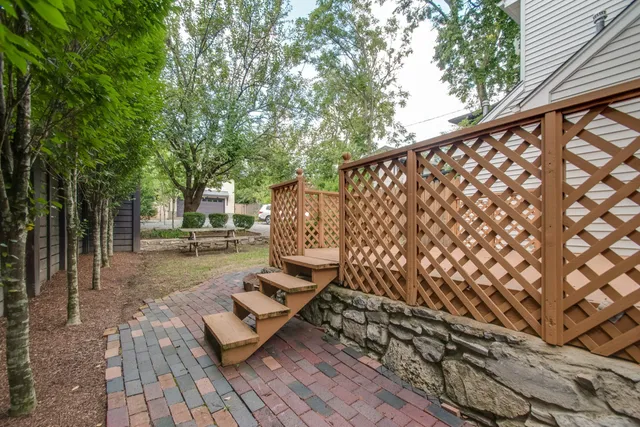 a view of a backyard with plants and large trees
