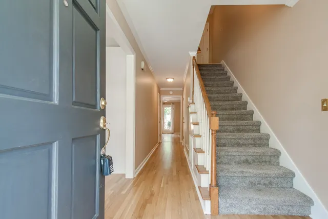 a view of a hallway with wooden floor and staircase
