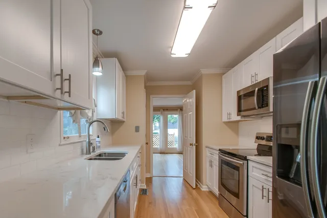 a kitchen with stainless steel appliances granite countertop a refrigerator a stove top oven a sink and dishwasher