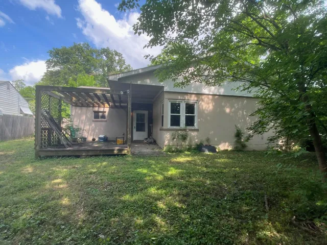 a backyard of a house with yard and outdoor seating