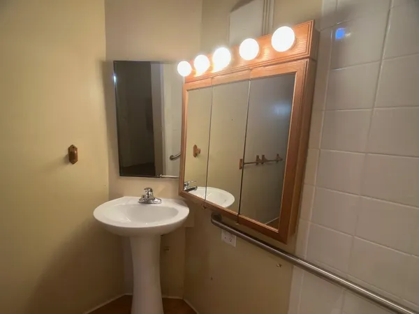 a bathroom with a sink shower and a mirror