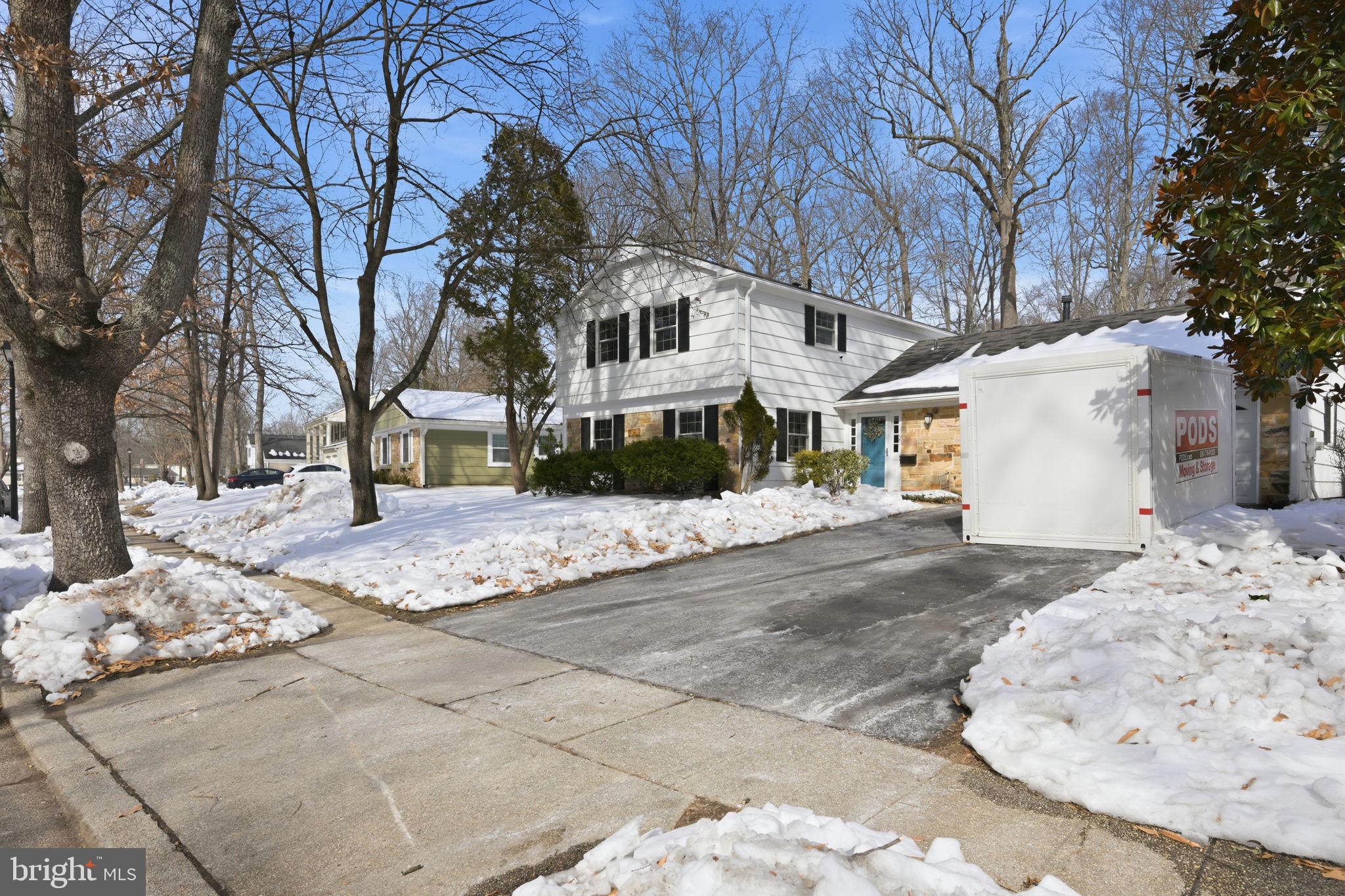 a view of a white house with a snow on the road