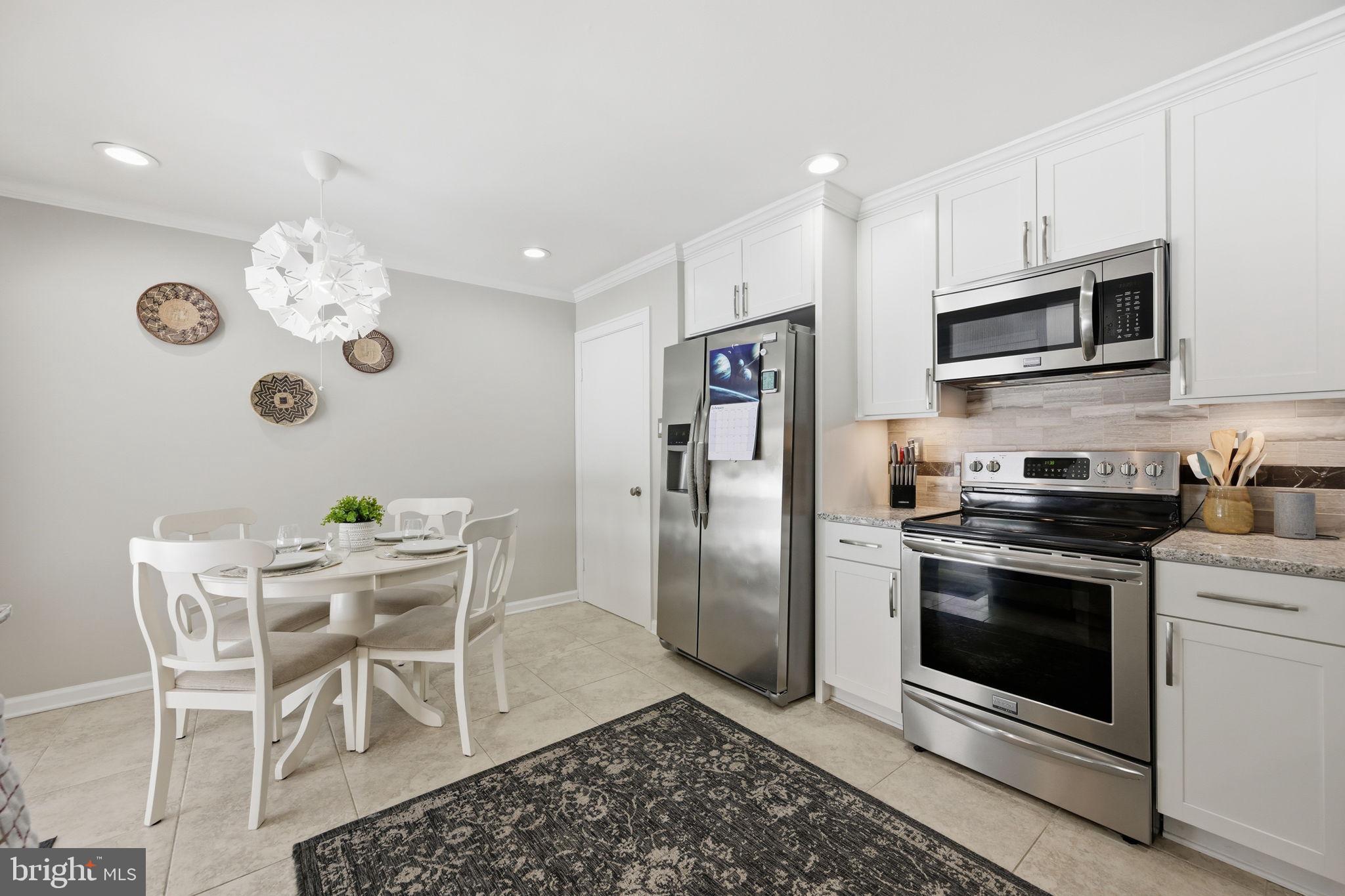 1708 Tarleton Way Crofton, MD 21114 - Photo 15 of 38 a kitchen with stainless steel appliances granite countertop a stove a sink and a microwave