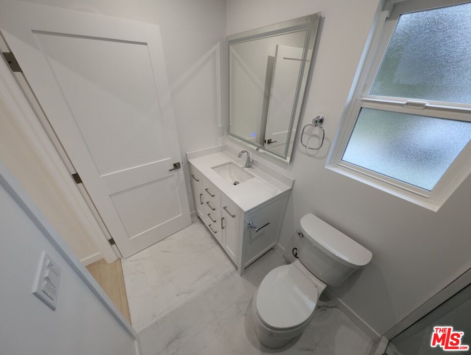 10623 Stanwin Avenue Mission Hills, CA 91345 - Photo 14 of 18 a bathroom with a sink mirror vanity and toilet