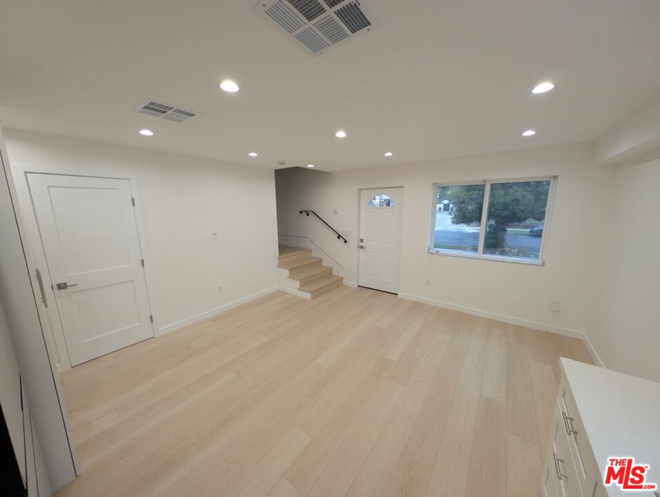 10623 Stanwin Avenue Mission Hills, CA 91345 - Photo 7 of 18 an empty room with wooden floor and windows