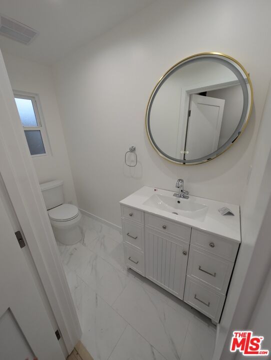 10623 Stanwin Avenue Mission Hills, CA 91345 - Photo 10 of 18 a bathroom with a toilet sink and mirror