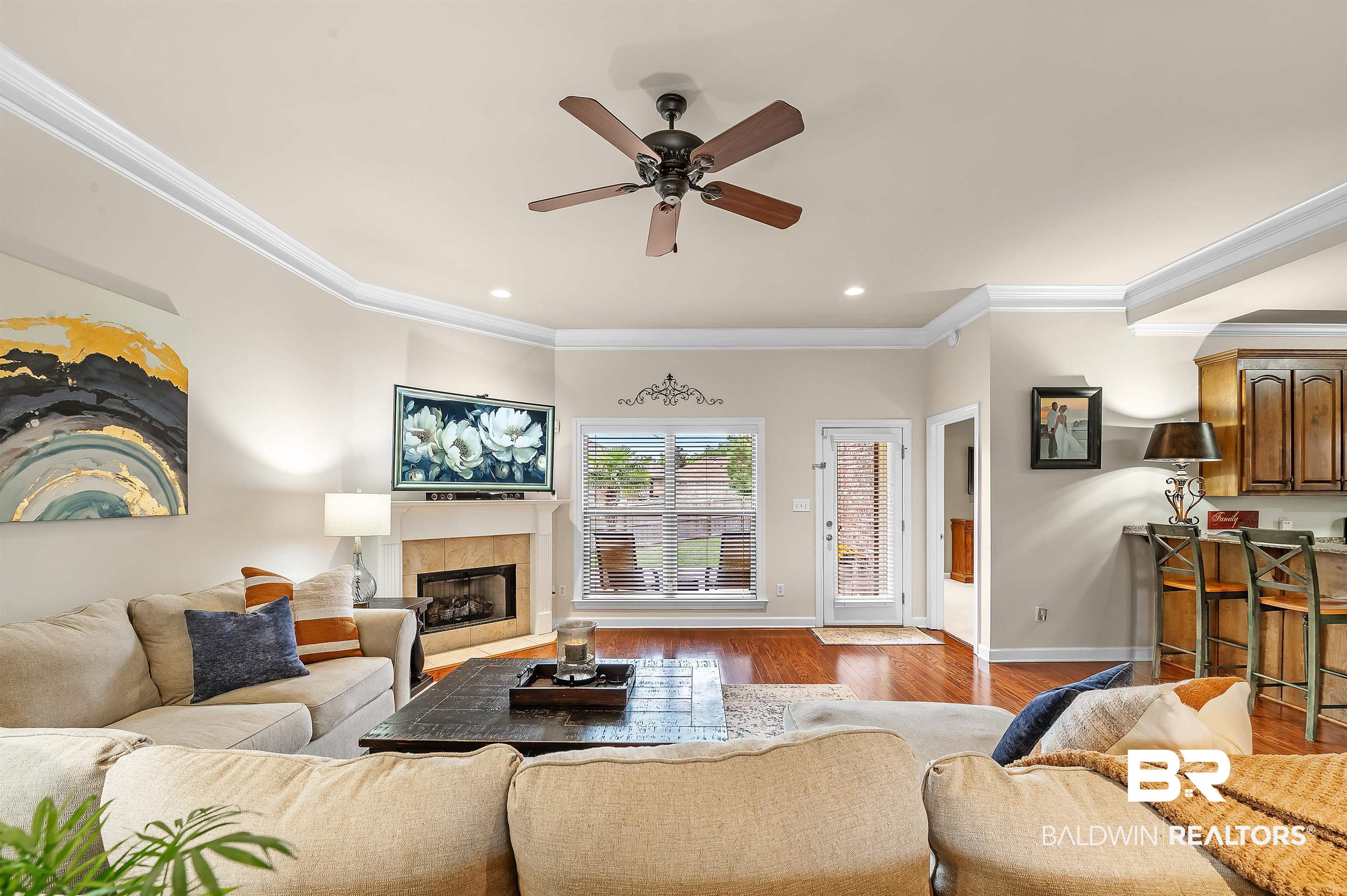 9376 Sable Court Daphne, AL 36526 - Photo 7 of 46 Living room featuring light wood-type flooring, ceiling fan, a fireplace, and ornamental molding