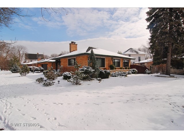 229 Blackhawk Road Riverside, IL 60546 - Photo 1 of 25 a front view of a house with a yard covered with snow