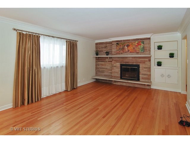 229 Blackhawk Road Riverside, IL 60546 - Photo 2 of 25 a view of an empty room with wooden floor fireplace and a window