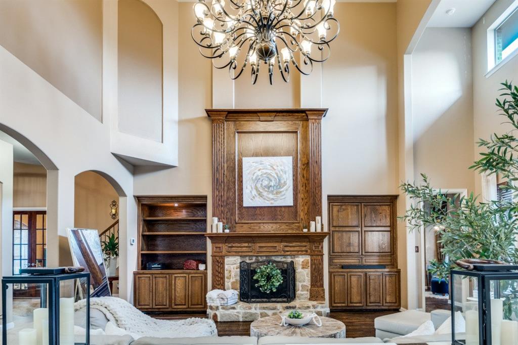 2810 Baker Street Sachse, TX 75048 - Photo 6 of 26 Living area featuring a high ceiling, arched walkways, a fireplace, a chandelier, and stairs