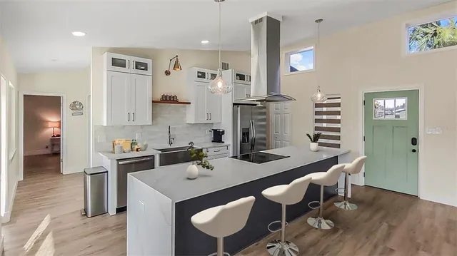 a kitchen with a dining table chairs cabinets and stainless steel appliances