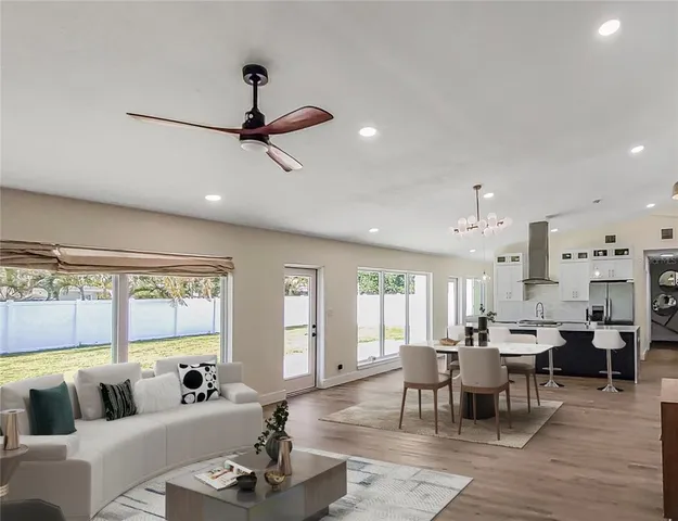 a living room with furniture kitchen view and a large window