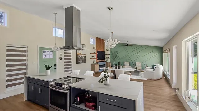 a kitchen with stainless steel appliances kitchen island granite countertop a stove and a view of living room