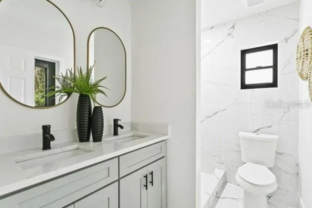 a bathroom with a toilet a sink and mirror