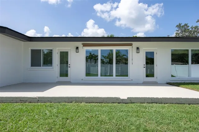 a backyard of a house with table and sofas