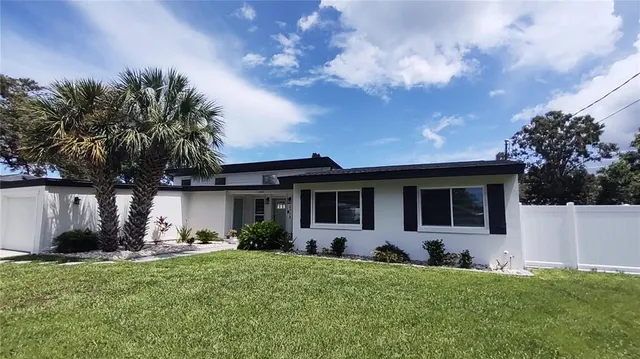 a front view of house with yard and trees