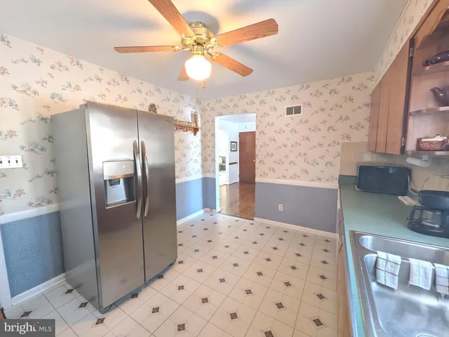 a kitchen with stainless steel appliances kitchen island granite countertop a refrigerator and a sink