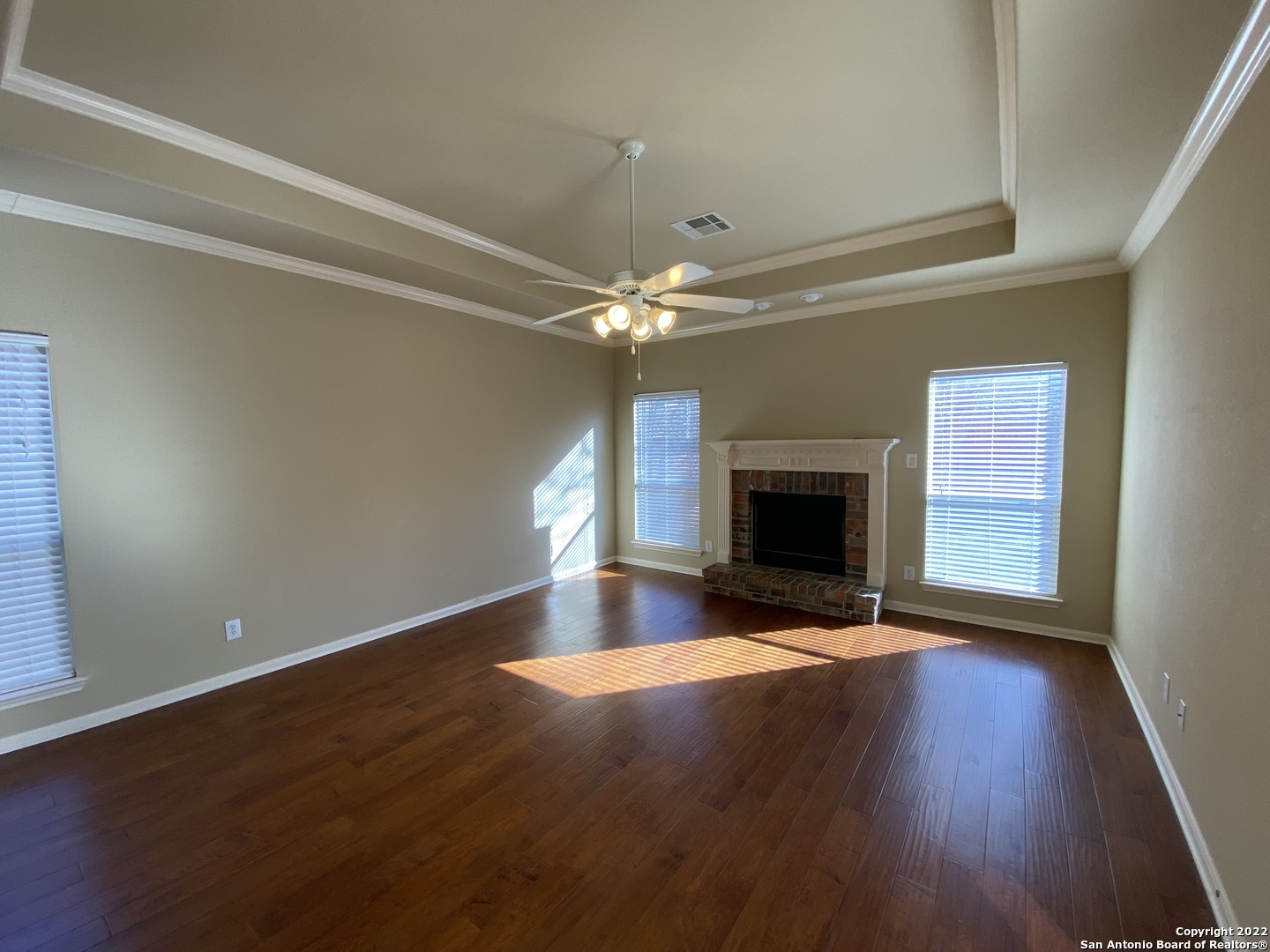 15518 Portales Pass Helotes, TX 78023 - Photo 8 of 25 a view of an empty room with wooden floor fireplace and a window