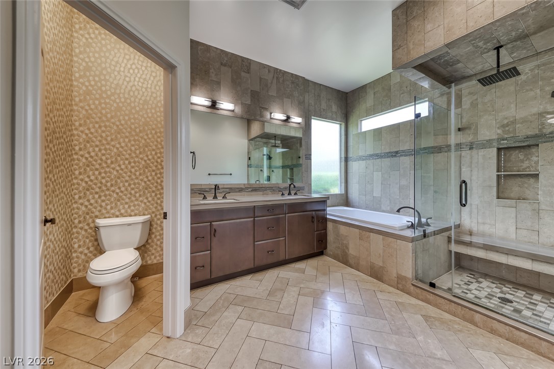 2122 Mooreview Street Henderson, NV 89012 - Photo 19 of 44 Luxurious bathroom with dual vanities, a deep soaking tub, and a spacious glass-enclosed shower.