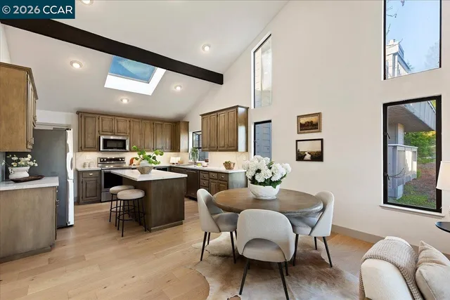 a room with stainless steel appliances kitchen island granite countertop furniture and a dining table