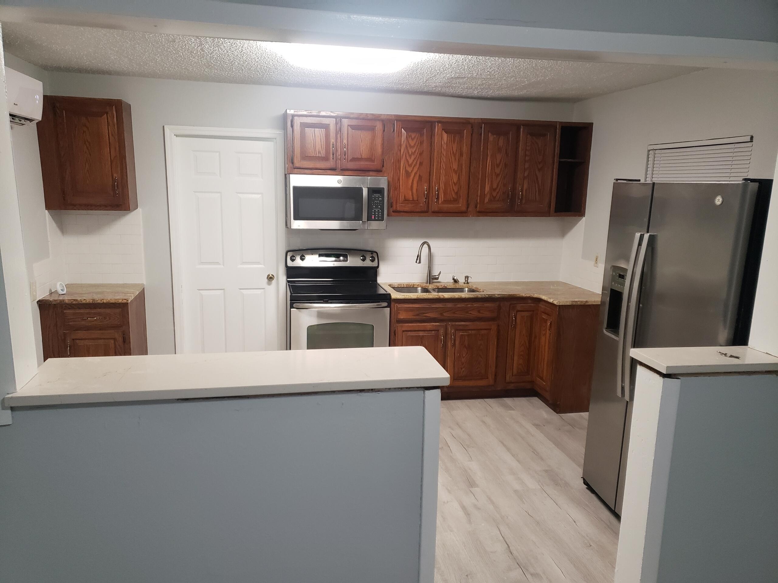 2106 Henry Street Northeast, Unit A Palm Bay, FL 32905 - Photo 2 of 8 a kitchen with stainless steel appliances a refrigerator a stove a sink and a refrigerator