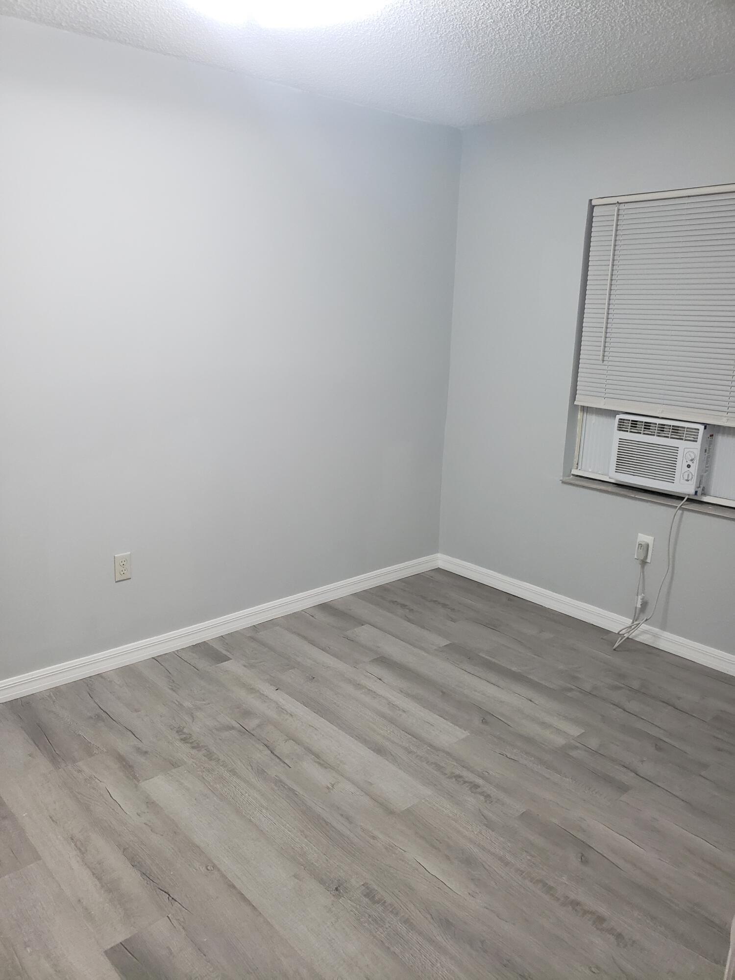 2106 Henry Street Northeast, Unit A Palm Bay, FL 32905 - Photo 5 of 8 a view of an empty room with wooden floor and a window
