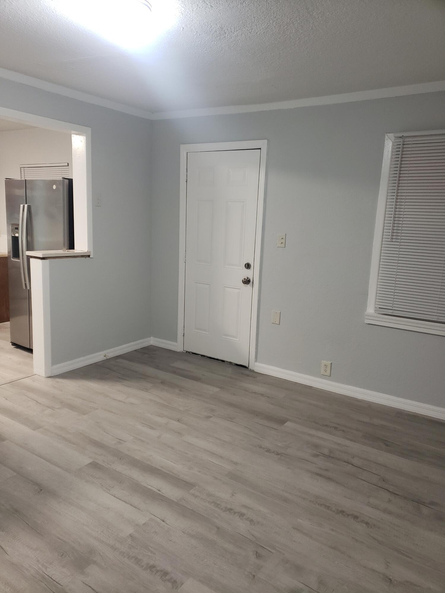 2106 Henry Street Northeast, Unit A Palm Bay, FL 32905 - Photo 6 of 8 a view of an empty room with wooden floor and a window