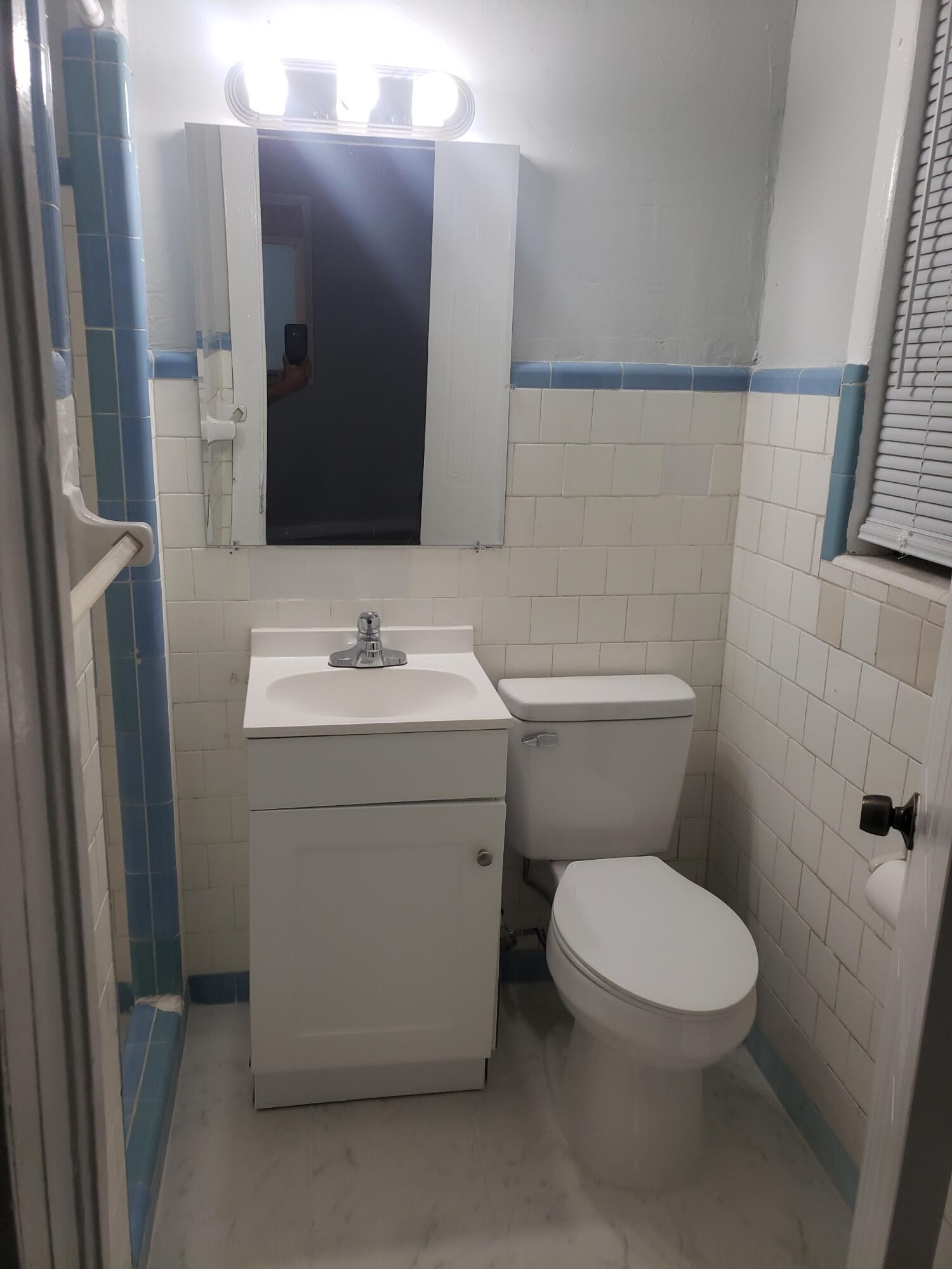 2106 Henry Street Northeast, Unit A Palm Bay, FL 32905 - Photo 8 of 8 a bathroom with a toilet sink and mirror