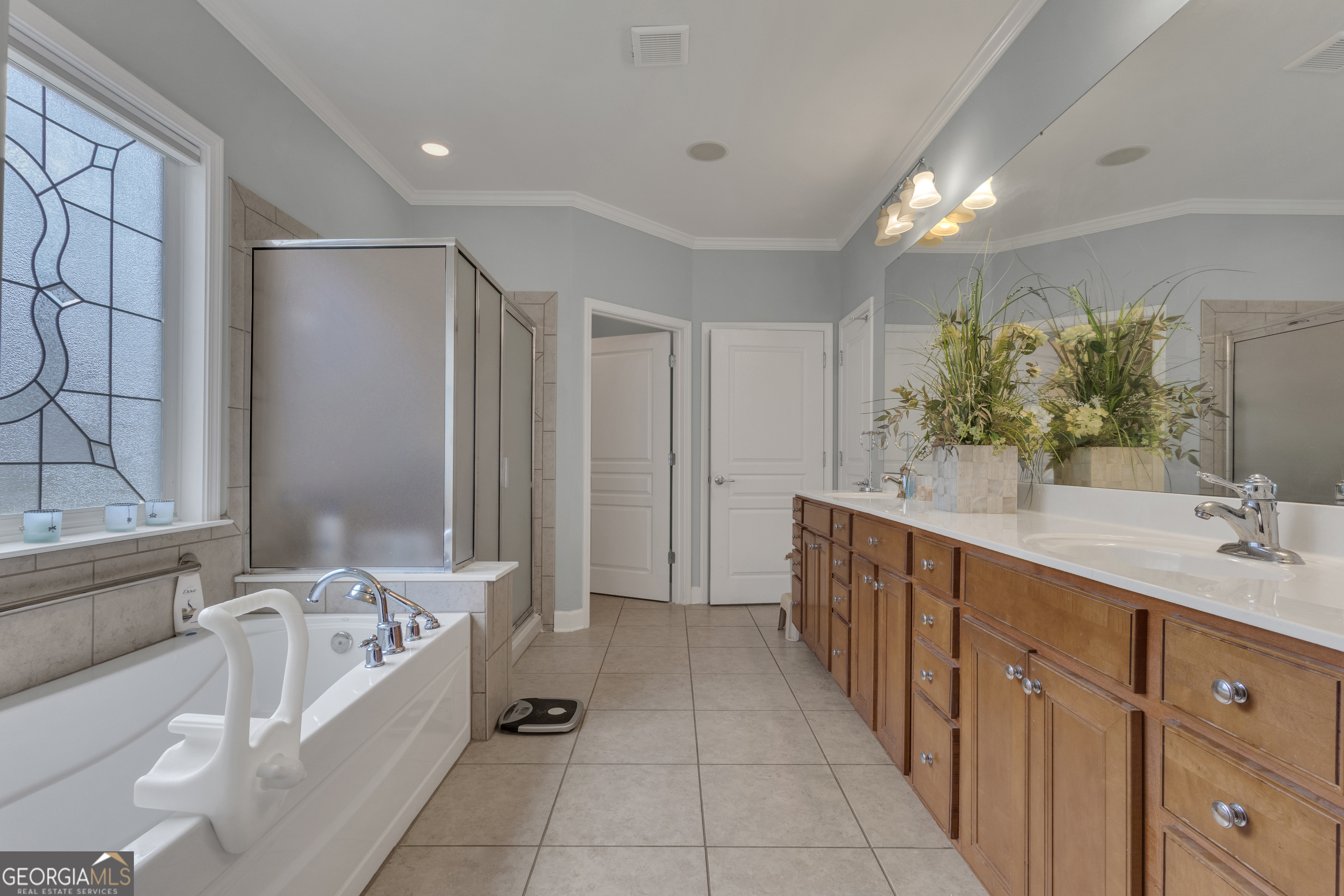 321 Anna Ruby Court Griffin, GA 30223 - Photo 37 of 81 a bathroom with a double vanity sink a large mirror and a bathtub