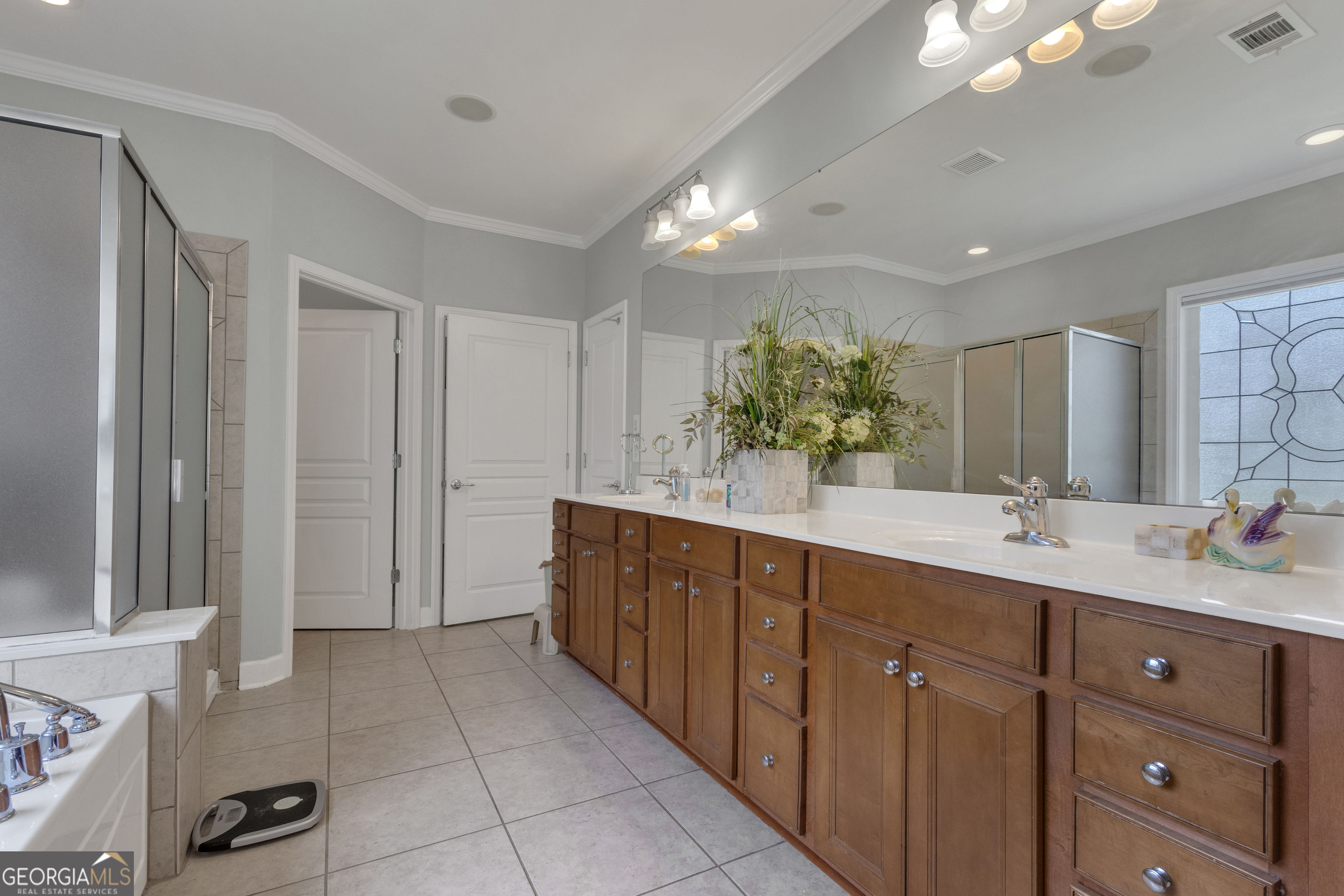 321 Anna Ruby Court Griffin, GA 30223 - Photo 38 of 81 a bathroom with a double vanity sink a mirror and a shower