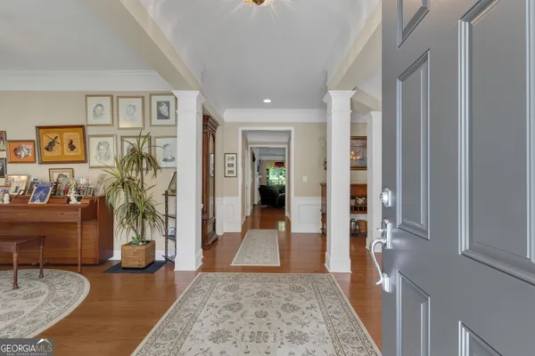 a view of a dining room with furniture a chandelier and wooden floor