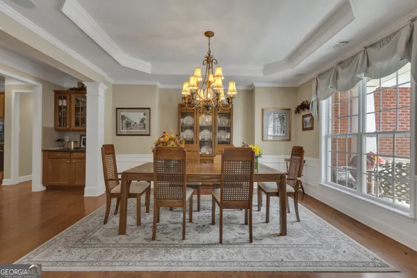 a view of a dining room with furniture a chandelier and wooden floor
