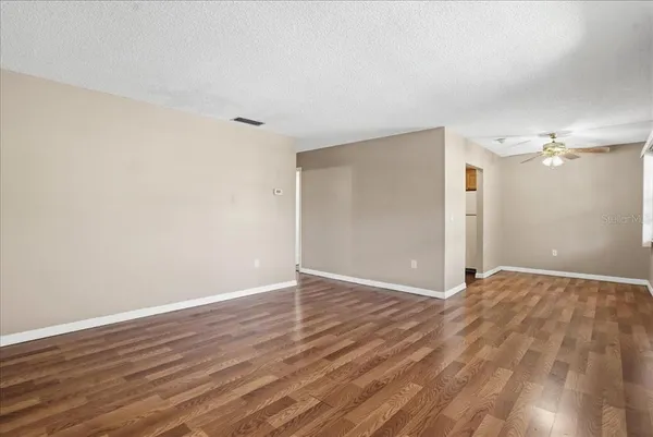 a view of an empty room with wooden floor
