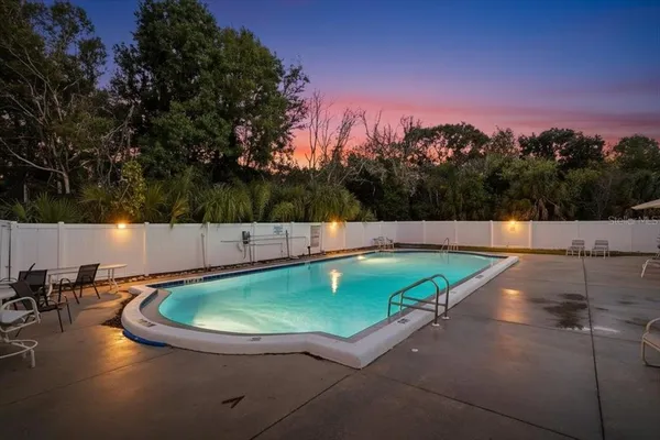 a view of a swimming pool with a patio and a yard