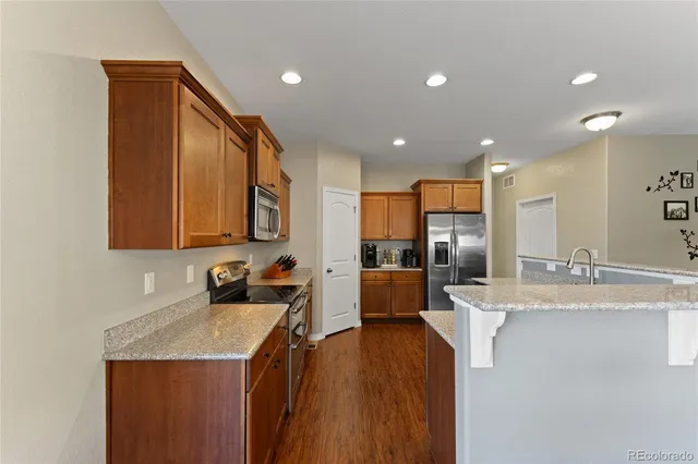 a kitchen with stainless steel appliances granite countertop a sink refrigerator and cabinets