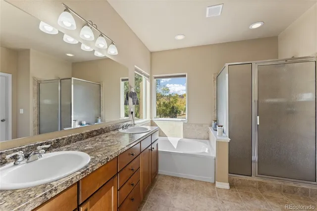 a spacious bathroom with a tub sink shower and mirror