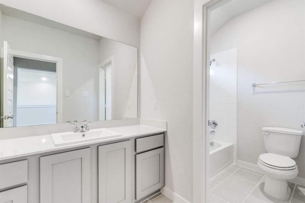 107 Huckleberry Road Forney, TX 75126 - Photo 20 of 30 a bathroom with a sink a toilet and a mirror