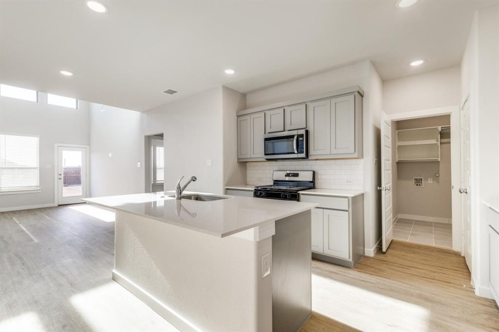 107 Huckleberry Road Forney, TX 75126 - Photo 7 of 30 a kitchen with stainless steel appliances granite countertop a sink a stove and a refrigerator