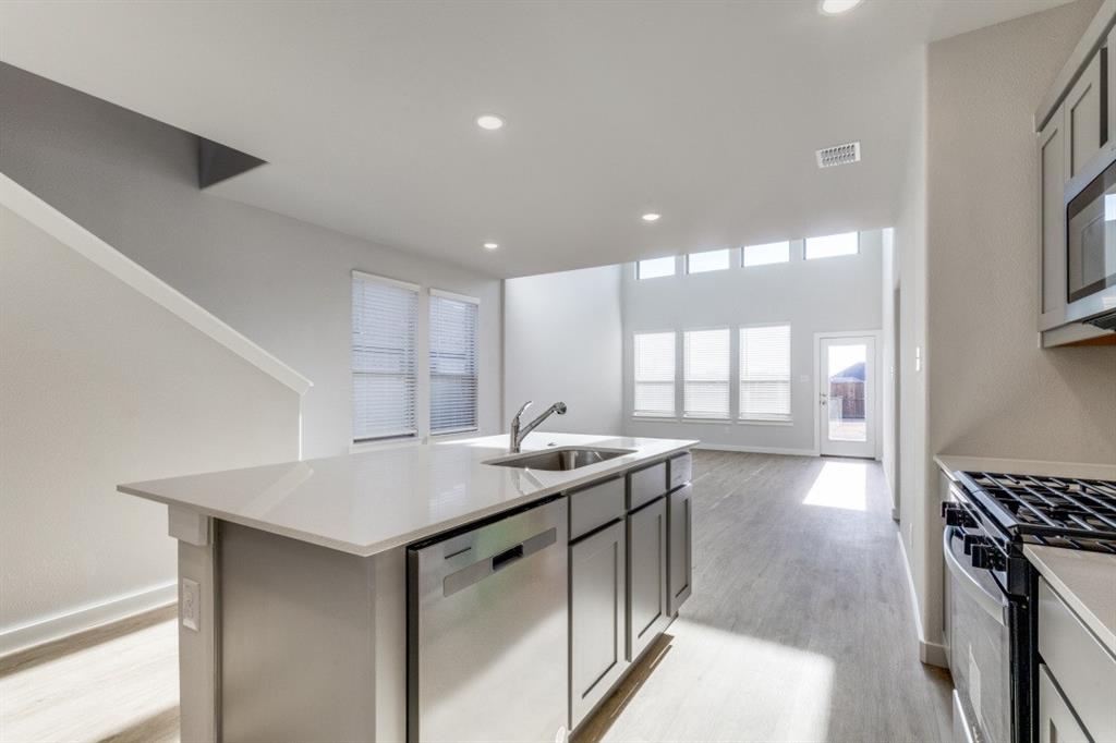 107 Huckleberry Road Forney, TX 75126 - Photo 8 of 30 a kitchen with stainless steel appliances granite countertop a sink a stove and a wooden floors