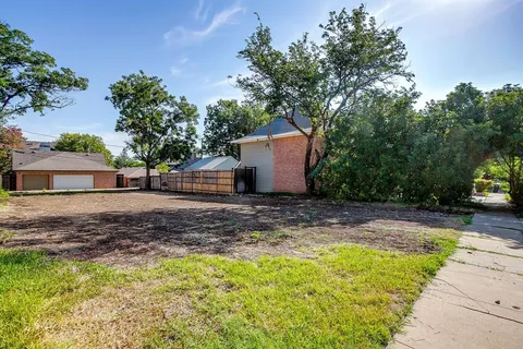 a view of a yard with plants and trees
