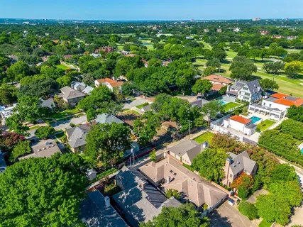 an aerial view of residential houses with outdoor space and trees